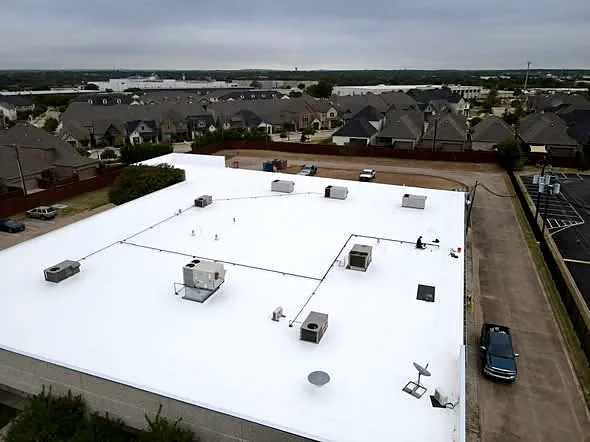 Aerial view of a white single-ply commercial roof installed by Nexgen