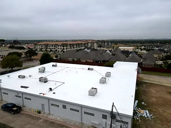 Aerial drone view of a completed white single-ply commercial roof on a distribution center