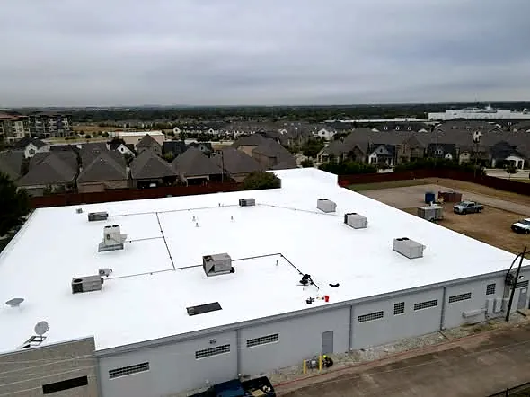 Aerial view of a finished white commercial roof on a distribution center