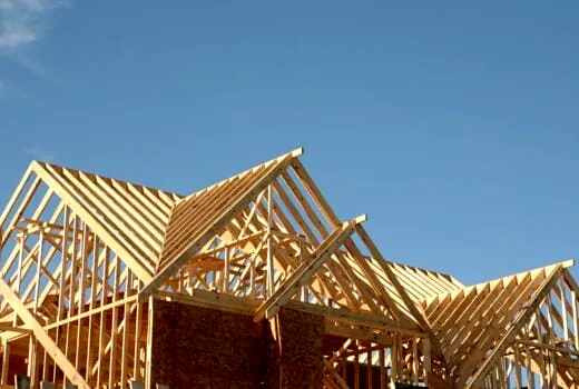 New construction roof trusses against a blue sky