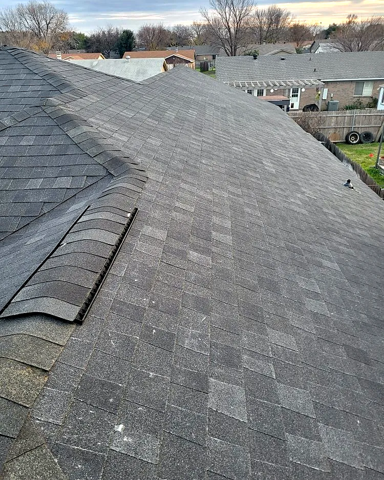 Close-up of new ridge cap shingles and roof vent